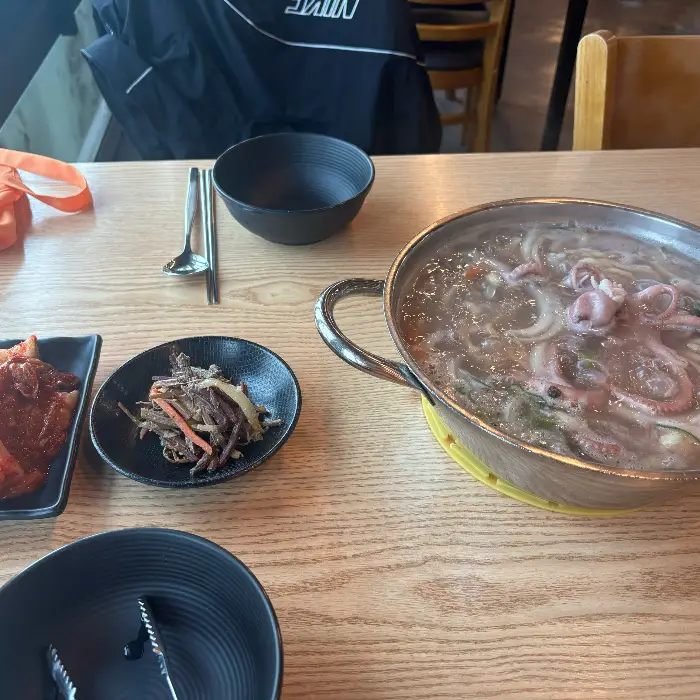 식탁 위에 놓인 칼국수 그릇과 수저