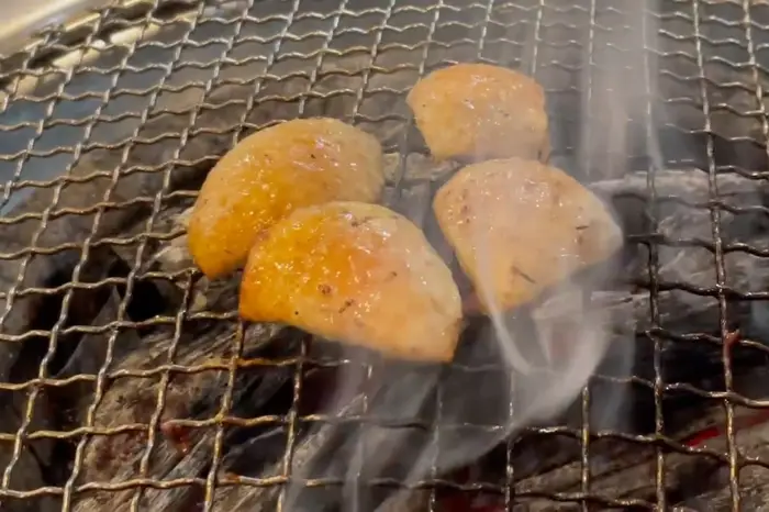 숯불 위에서 노릇하게 익어가는 오리고기 조각들