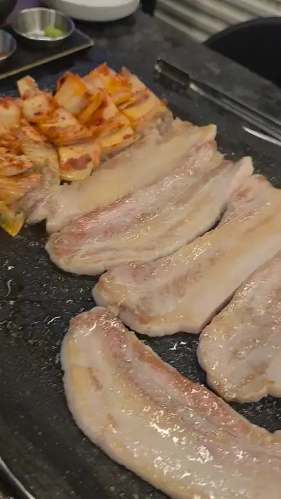 불판 위에 올라간 삼겹살과 김치