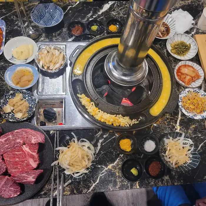 테이블 중앙의 화로와 다양한 반찬들