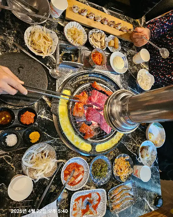 불판 위에서 익어가는 고기와 치즈 테두리