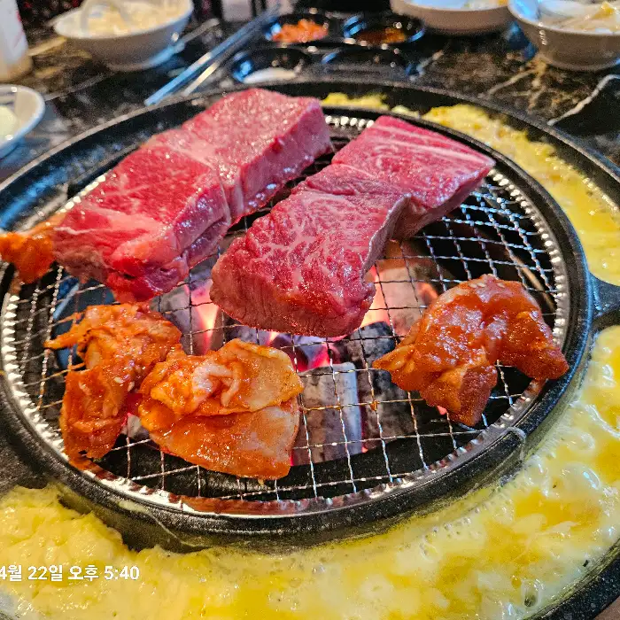 화로 위에서 맛있게 익어가는 두툼한 고기 덩어리들