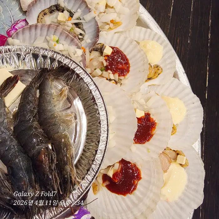 불판 위에서 익어가는 조개와 새우