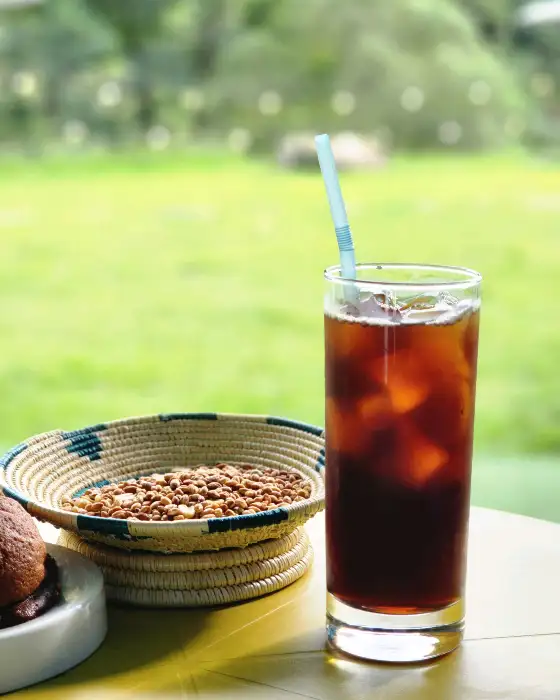 아이스커피 한 잔과 볶은 곡물이 담긴 바구니