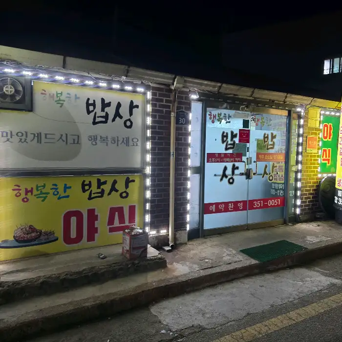 저녁 시간에 불이 켜진 '행복한 밥상' 식당 외관