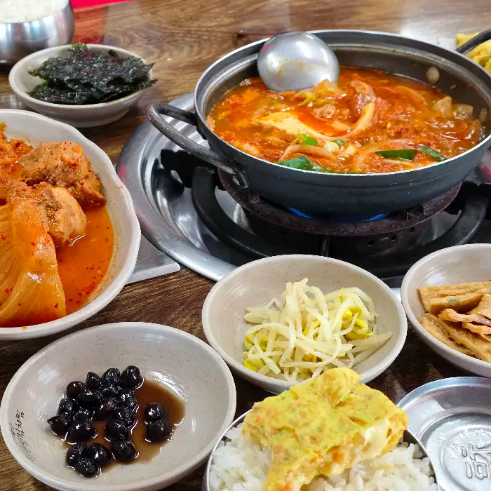 여러 반찬과 함께 김치찌개가 끓고 있는 모습