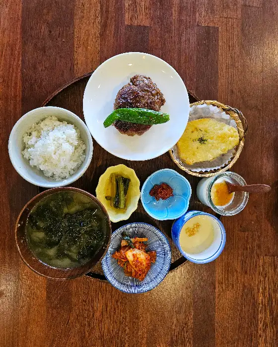 정갈하게 차려진 밥과 여러 가지 반찬, 떡갈비, 계란찜, 샐러드 등의 모습