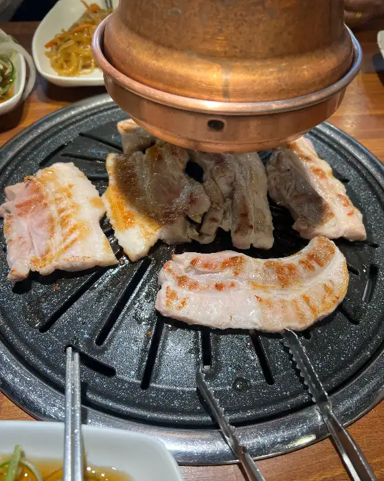 다양한 종류의 고기들이 불판 위에 올라가 있는 모습