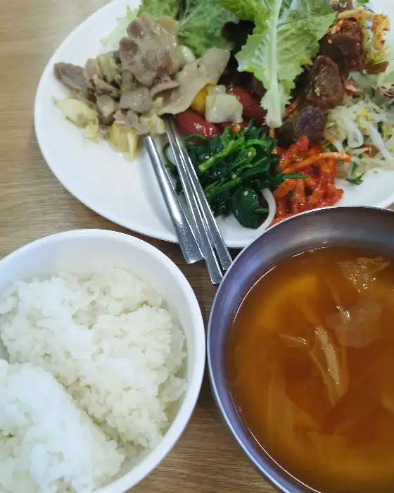 밥, 수육, 샐러드, 국이 담긴 접시
