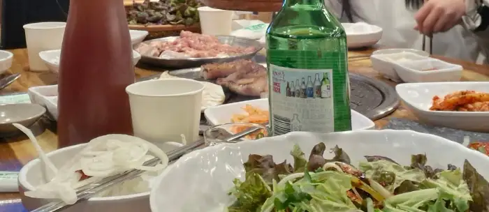 식사 중인 테이블 모습, 소주병도 보인다.