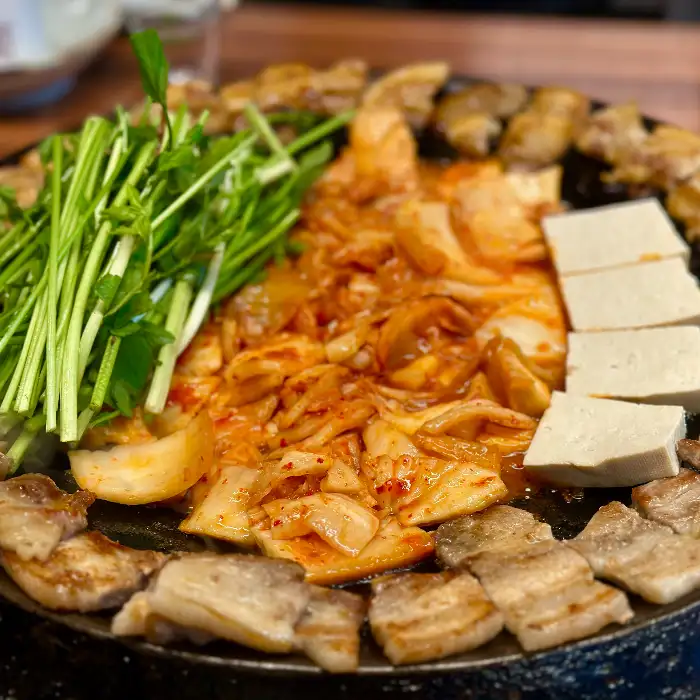 김치전골과 두부, 그리고 채소가 담긴 냄비