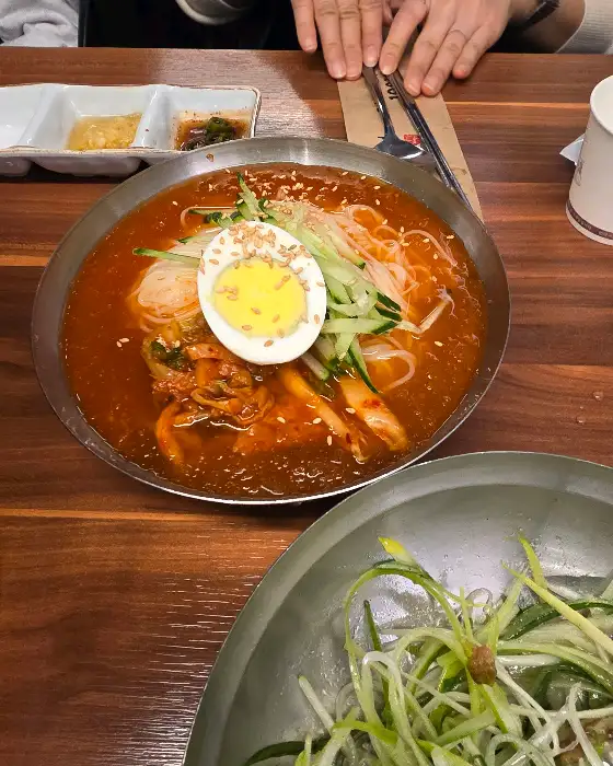 김치와 계란, 채소가 얹어진 볶음밥이 담긴 그릇