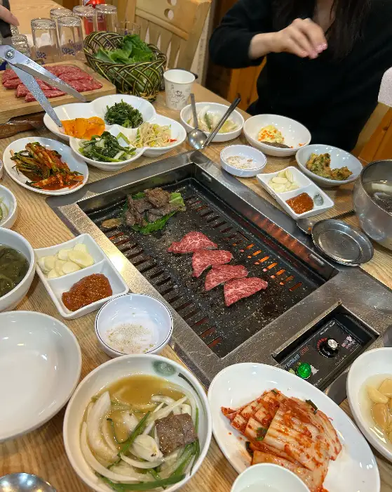 다양한 반찬과 함께 불판에서 구워지는 고기