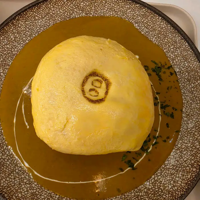 커리 소스 위에 올려진 오믈렛