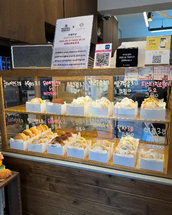 진열대에 가지런히 놓인 다양한 종류의 도넛들