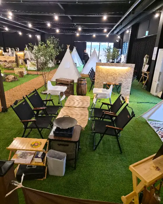 바베큐팩토리 내부, 텐트와 캠핑 테이블, 의자, 그리들이 놓인 모습