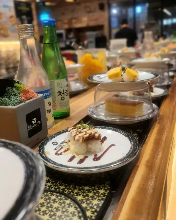 회전 초밥 레일과 여러 접시의 초밥