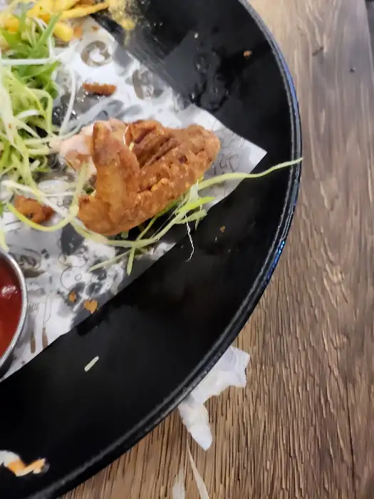 접시 가장자리에 놓인 치킨 조각과 튀김옷의 바삭한 질감