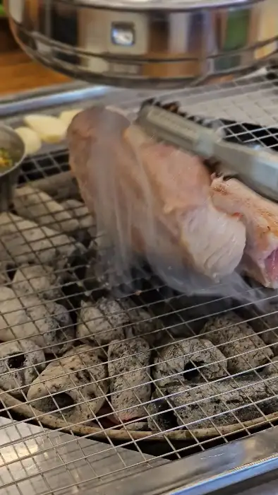 숯불 위에서 익어가는 돼지고기 조각