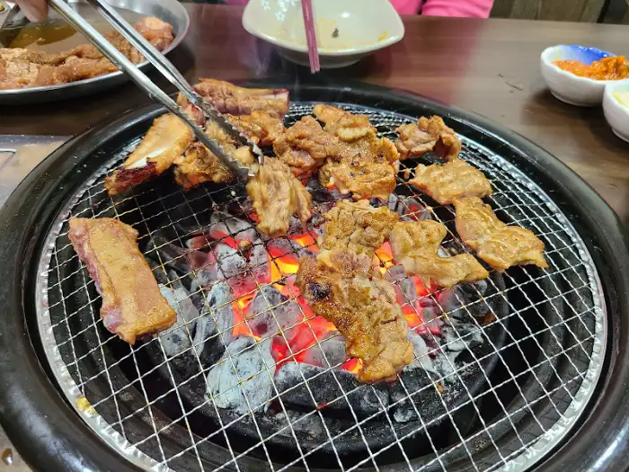 다양한 부위의 돼지고기가 숯불 위에서 익는 모습