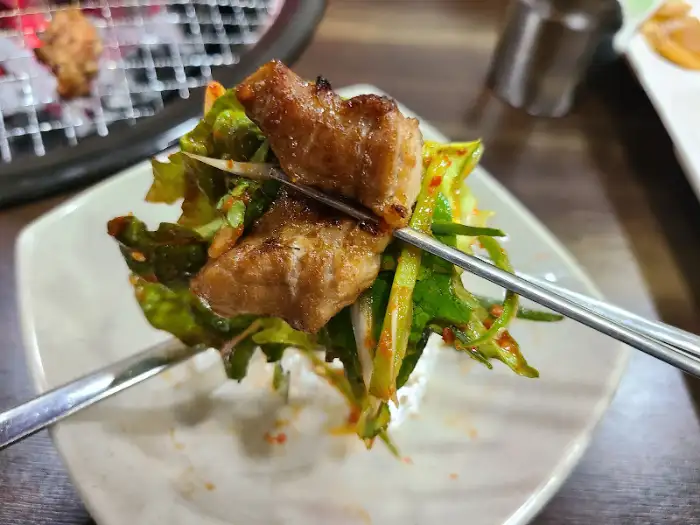 파절이와 함께 집어 올린 돼지고기 한 점