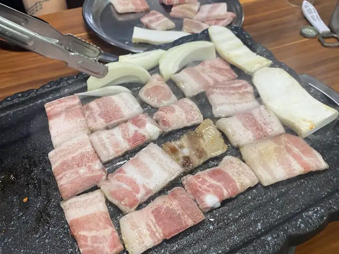 불판 위에 구워지는 냉삼겹살과 양파
