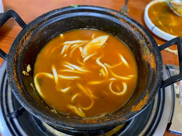 칼국수 면발이 담긴 얼큰한 국물 냄비