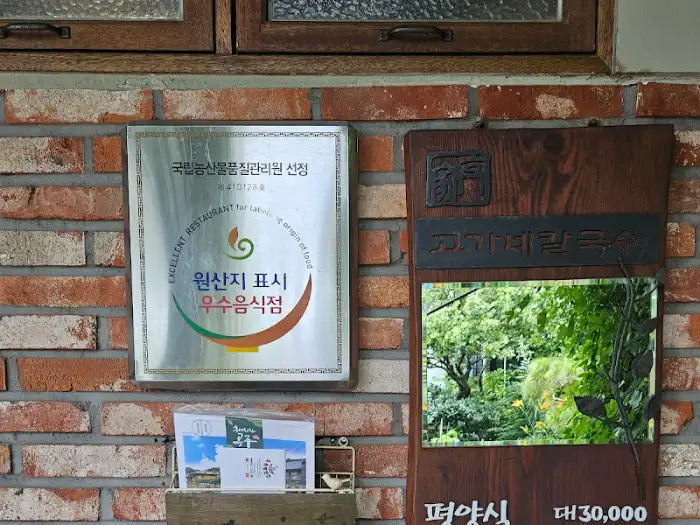 건물 외벽에 붙어있는 원산지 표시 우수음식점 인증패