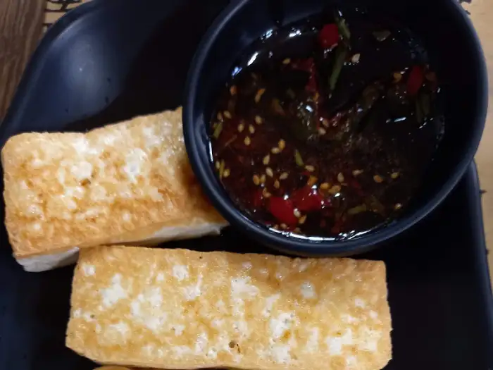 노릇하게 구워진 두부구이 조각과 함께 나온 간장 소스