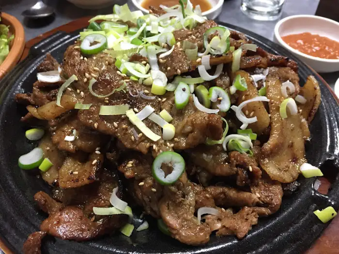 가까이에서 본 돼지불백, 윤기 나는 고기와 파채, 깨가 뿌려져 있다.