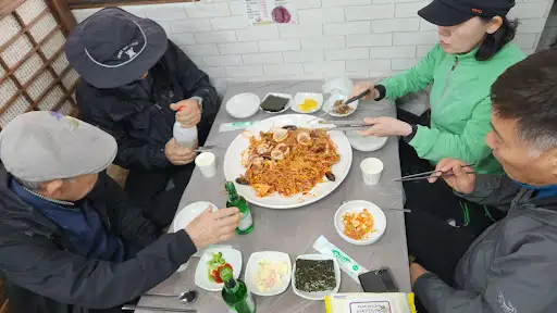 테이블에 둘러앉아 식사하는 사람들