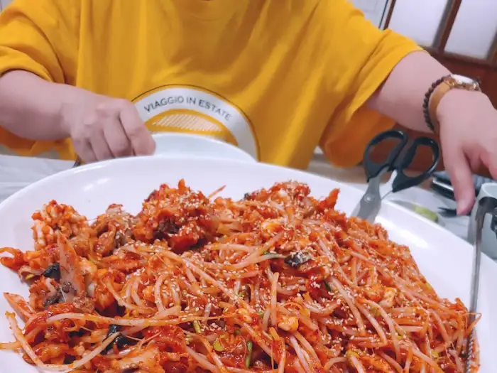 음식을 덜어 먹고 있는 사람의 손과 음식