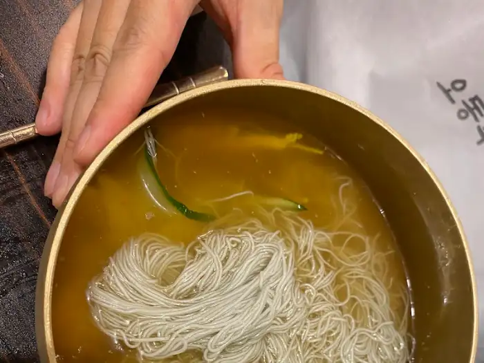 손으로 집어 올리는 냉면