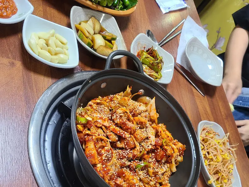 불판 위에 놓인 붉은 양념의 삼겹살