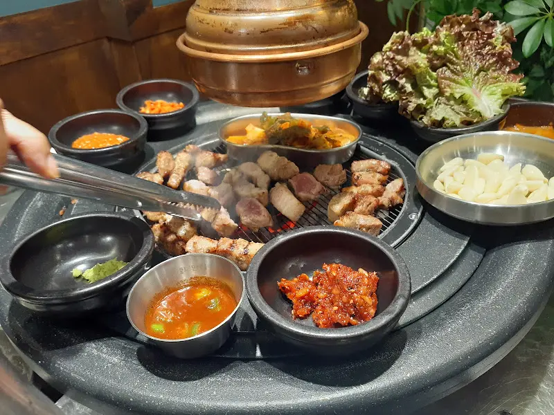 다양한 소스와 함께 구워진 고기를 즐기는 모습