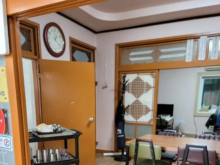 식당 내부의 낡은 시계와 탁자. 오래된 듯한 분위기를 더한다.