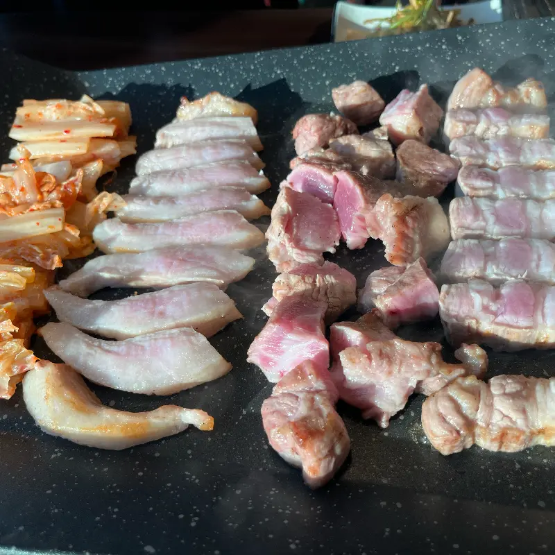 불판 위의 삼겹살, 김치, 마늘