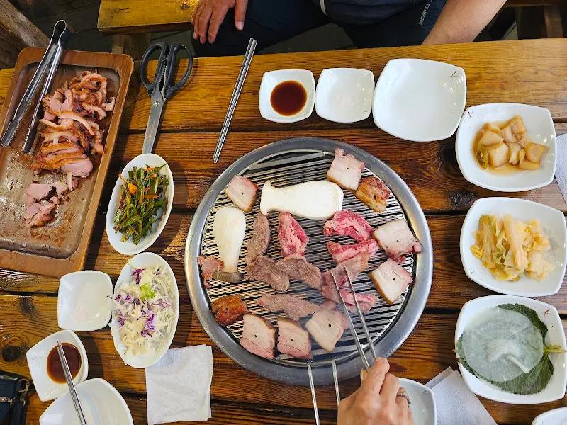 숯불 위에서 맛있게 구워지고 있는 삼겹살과 버섯