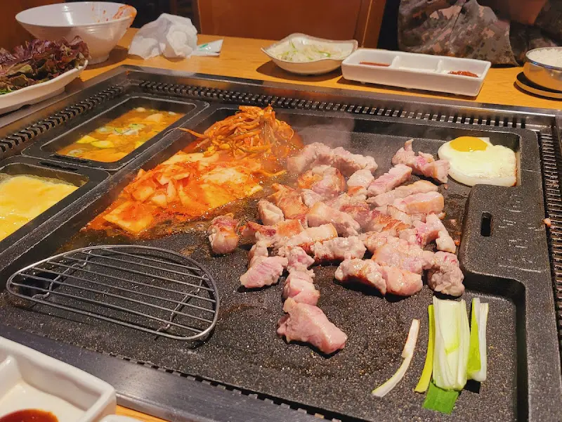 솥뚜껑 위에 올려진 삼겹살과 김치