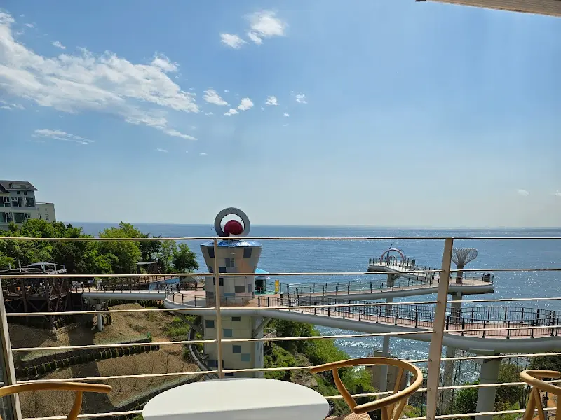 테이블에 앉아 바다를 바라보며 여유로운 시간을 보내는 사람들