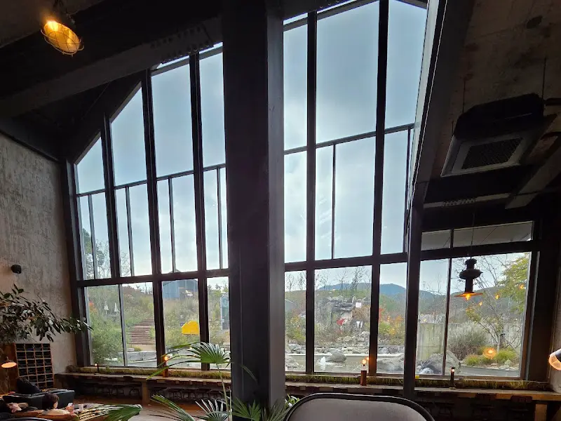 높은 천장과 통창으로 들어오는 햇살이 인상적인 카페 내부.