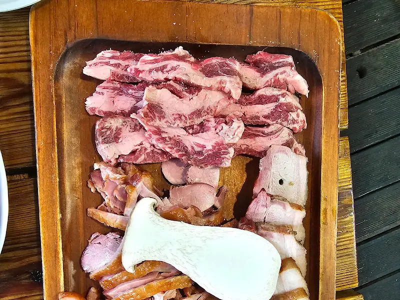 초벌된 오리고기와 삼겹살, 훈제오리가 나무 도마 위에 담겨 나온 모습