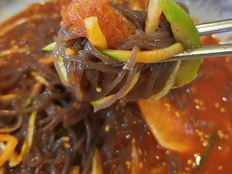 젓가락으로 냉면 면발 들어올리는 모습