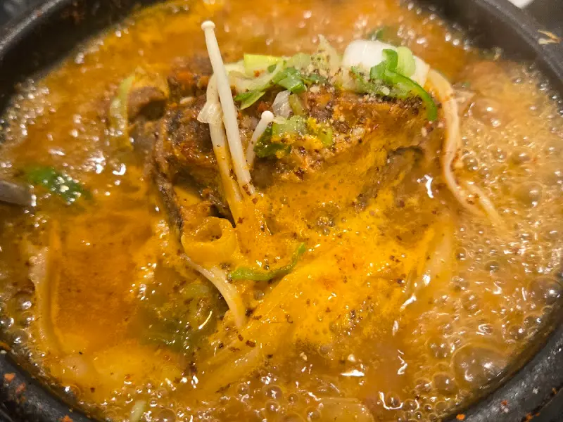 뼈해장국의 클로즈업 사진. 뽀얀 국물과 푸짐한 건더기가 인상적이다.