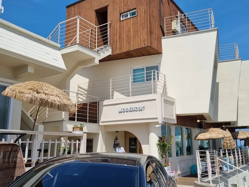 하얀색 외벽에 'MOOKHO287'이라는 글자가 새겨진 카페 건물