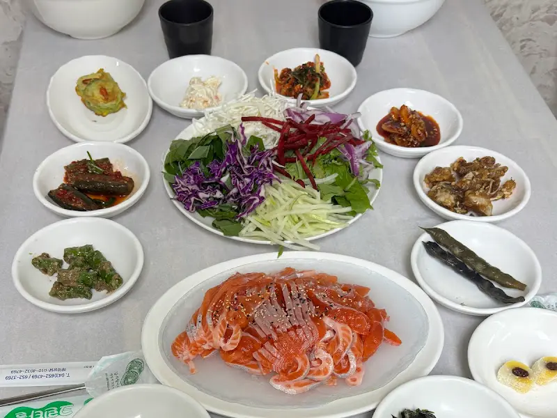 푸짐하게 차려진 밑반찬과 송어회 한 상 차림