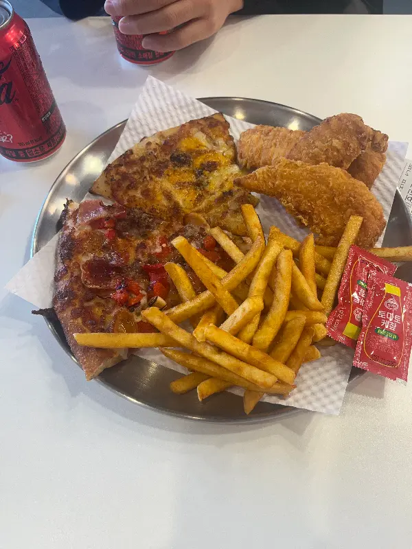 슈퍼잭슨 피자 한 조각과 감자튀김, 치킨 텐더가 함께 담긴 접시