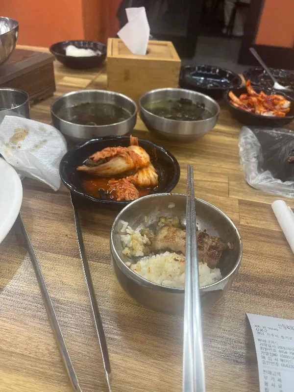 다양한 밑반찬과 쌈 채소가 푸짐하게 차려진 테이블