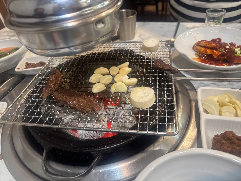 숯불 위에서 구워지는 고기와 마늘