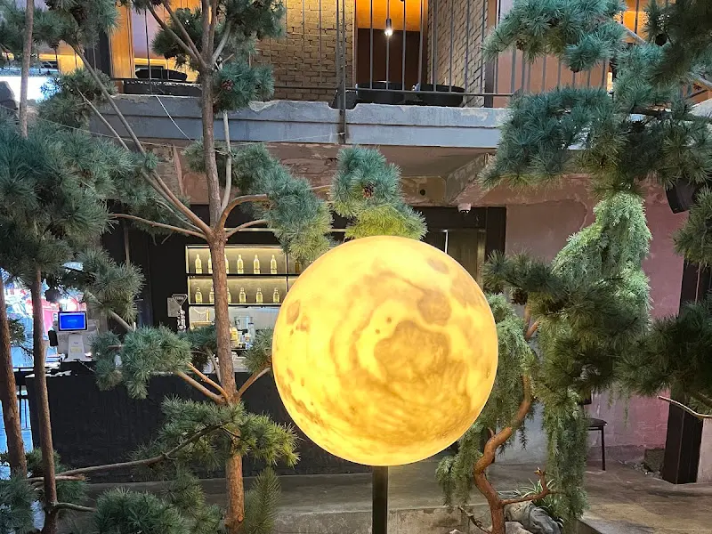 달 조형물을 중심으로 푸른 소나무가 배치되어 있어 몽환적인 분위기를 자아낸다.